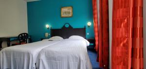 a bedroom with a bed with blue walls and red curtains at Metropol in Paris