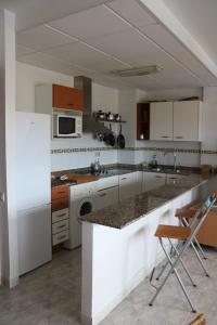 cocina con armarios blancos y encimera en Apartamento Eucaliptus A - Delta del Ebro, en L'Eucaliptus