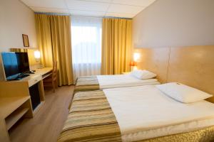 a hotel room with two beds and a television at Tallinn Viimsi Spa & Waterpark in Tallinn