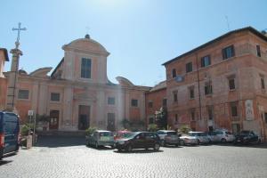 duży ceglany budynek z samochodami zaparkowanymi na parkingu w obiekcie Ben's Houses - Trastevere apartment w Rzymie