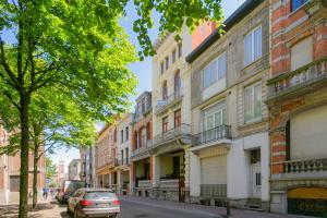 a street with buildings and a car parked on the street at Villa Apollo in Blankenberge