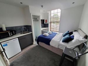 a bedroom with a bed and a kitchen with a sink at The Ashcroft Apartments - Free Parking in Manchester