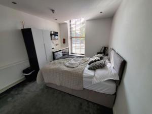 1 dormitorio con cama y ventana en The Ashcroft Apartments - Free Parking, en Mánchester