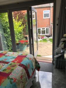 a bedroom with a bed and a sliding glass door at Circles Guest House in Pewsey