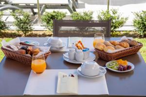 uma mesa azul com cestas de alimentos para pequeno-almoo e sumo de laranja em Luna Hotel de Tbua na Tbua