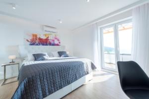 a white bedroom with a bed and a chair at Villa Vega in Dubrovnik