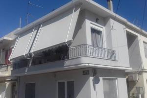 a white house with a balcony on top of it at Paris house 1 in Patra