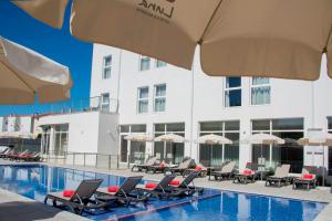 a hotel swimming pool with lounge chairs and umbrellas at Luna Hotel de Tábua in Tábua