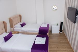 a room with two beds and a flat screen tv at Motel KVELE in Novi Pazar