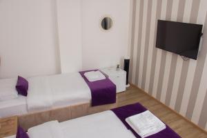 a room with two beds and a flat screen tv at Motel KVELE in Novi Pazar