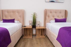two beds in a room with purple pillows at Motel KVELE in Novi Pazar