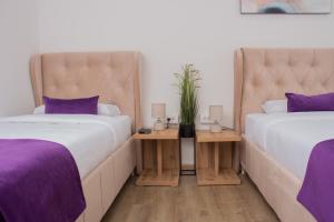 two beds in a room with purple pillows at Motel KVELE in Novi Pazar