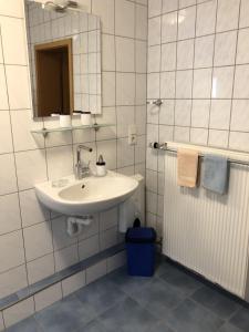 uma casa de banho branca com um lavatório e um espelho em Ferienwohnung Wiesental em Meisburg