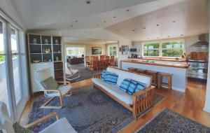 a living room with a couch and a kitchen at The Waiheke Lodge in Onetangi