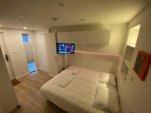 a bedroom with a bed with a tv on the wall at Stylish house in the heart of Breda city center in Breda