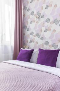 モスクワにあるУютные апартаментыのベッドルーム1室(紫色の枕と壁付)