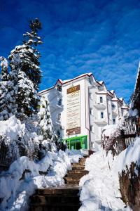 un edificio con neve sulle scale di fronte di VICTOR Hotel Resort & SPA a Truskavec'