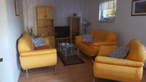 - un salon avec des chaises jaunes et une table dans l'établissement Mühlenblick, à Klütz