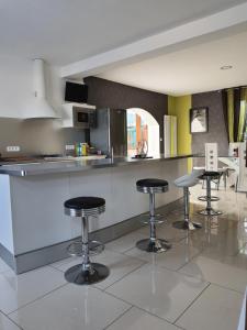 a kitchen with three bar stools in a room at Gite Ardennes in Deville