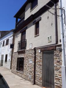 um velho edifício de tijolos com uma porta numa rua em Posada del Teso, Norte provincia Cáceres, Tierras de Granadilla em Cerezo