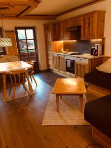 a living room with a table and a kitchen at Aparthaus Hubertus in Alpbach