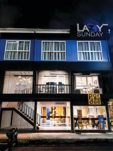 a blue and white building with a sign on it at Lazy Sunday hostel in Bangkok