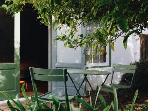 two chairs and a table in front of a door at MooiBaai in Hout Bay