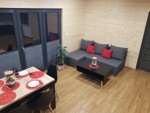 sala de estar con sofá y mesa con almohadas rojas en Osada Orlica 2 en Lasowka