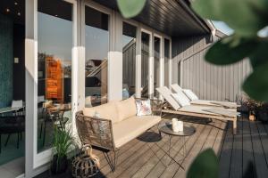 d'une terrasse avec des chaises en osier et une table. dans l'établissement Townhouse Stadt Hamburg Wismar, à Wismar