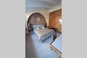 a bedroom with a bed and a table at Loft atelier dans ancien domaine viticole in Moux