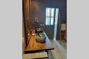 Habitación con un bol sobre una mesa de madera en Loft atelier dans ancien domaine viticole, en Moux 8 fotos más