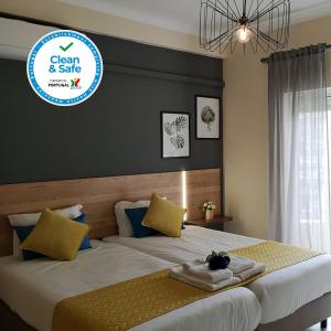 ein Schlafzimmer mit 2 Betten und ein Schild, auf dem sauber und sicher steht in der Unterkunft Kiss - Apartamentos Turísticos in Albufeira