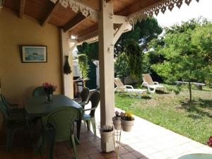 een patio met een tafel en stoelen op een huis bij Le clos de la Plage - Villa vintage avec jardin privatif- 500m de la plage - 6 personnes in Dolus d'Oléron