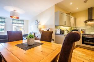 a kitchen and dining room with a wooden table and chairs at Buxton centre cosy cottage with free secure parking in Buxton