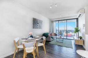 a dining room and living room with a table and chairs at KOZYGURU SOUTH BRISBANE FUNKY 1 BED APT FREE PARKING QSB027-1810 in Brisbane