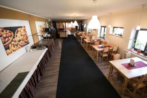 a restaurant with tables and chairs and a long corridor at Váňův statek in Pelhřimov