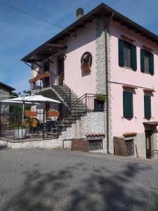 a pink house with stairs and a table and chairs at I BARSAN in Bagnone