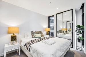 una camera bianca con due letti e un grande specchio di KOZYGURU FORTITUDE VALLEY DESIGNER GRADE 2 BED APT FREE PARKING QFV179-1401 a Brisbane