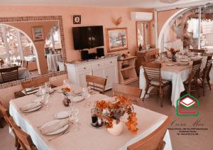 a dining room with tables and chairs and a television at Casa Mia in Ouled Kacem