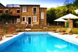una piscina con sillas y una casa en Villa Bazjaki - Beautiful stone villa in Istria with private pool, en Livade