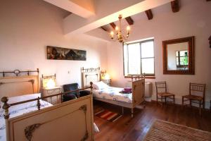 a bedroom with two beds and a table and chairs at Villa Bazjaki - Beautiful stone villa in Istria with private pool in Livade +13 photos