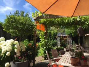 a patio with a table with flowers and an umbrella at B&B Bella en Basiel in Bruges
