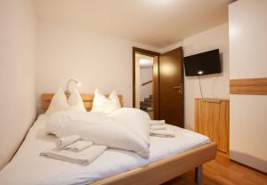 a bedroom with a bed with white sheets and towels at Chalet Resort Montafon I - Chalets & Chalet-Apartments in Sankt Gallenkirch