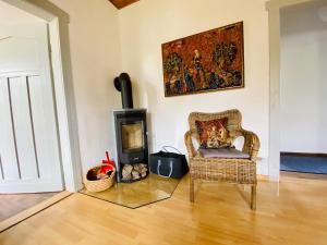 a living room with a chair and a fireplace at Ferienwohnung Schepkowski in Großbreitenbach