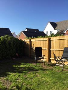 two chairs in a yard next to a fence at 2 Lapwing Drive in Hayle