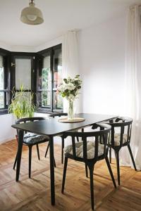 a dining room table with chairs and a vase of flowers at Modern Cozy Apartment - NEW in Kyustendil