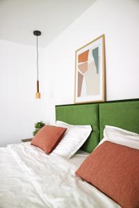 a bedroom with a green and white bed with two pillows at Modern Cozy Apartment - NEW in Kyustendil