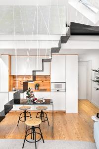 a kitchen and living room with white cabinets and a staircase at Jasmine Loft in Porto
