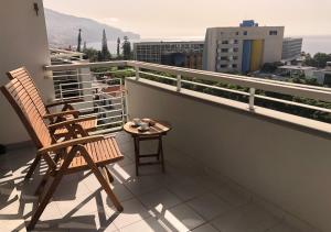 balcone con 2 sedie e tavolo di Dona I House - In Funchal with free parking a Funchal