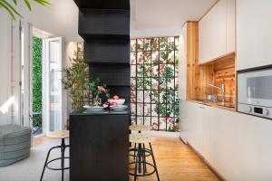 a kitchen with a counter and stools in a room at Jasmine Loft in Porto